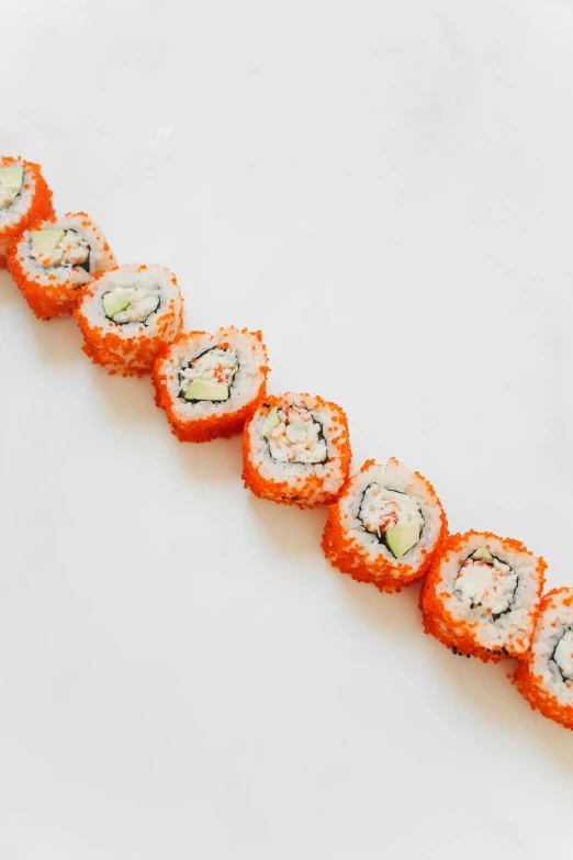 a white plate topped with lots of sushi, orange fluffy spines, 6 pack, vibrant threads, 8mm