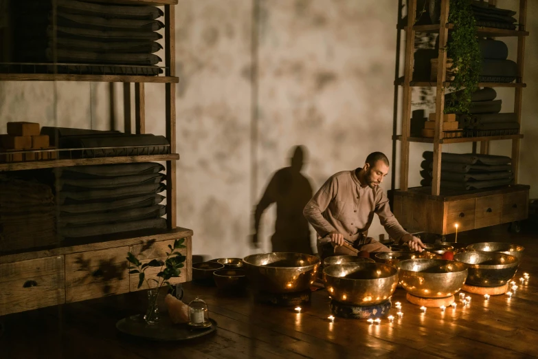 a man standing in a room filled with pots and pans, by Jan Tengnagel, trending on unsplash, light and space, dance meditation, in an ancient altar, gurney with ambient lighting, sydney hanson