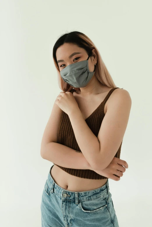 a woman wearing a face mask in front of a white background, inspired by Gao Cen, trending on pexels, renaissance, wearing a low cut tanktop, gray color, singapore, akali