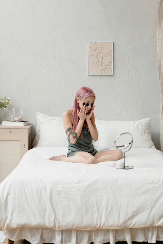a woman with pink hair sitting on a bed, inspired by Elsa Bleda, trending on pexels, chrome mask, with a mirror, full body sarcastic pose, skincare