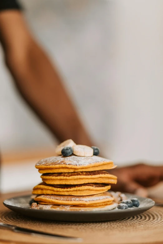 a stack of pancakes sitting on top of a plate, a still life, by Julia Pishtar, trending on pexels, made of food, natural morning light, blueberry and orange and teal, focus on full - body