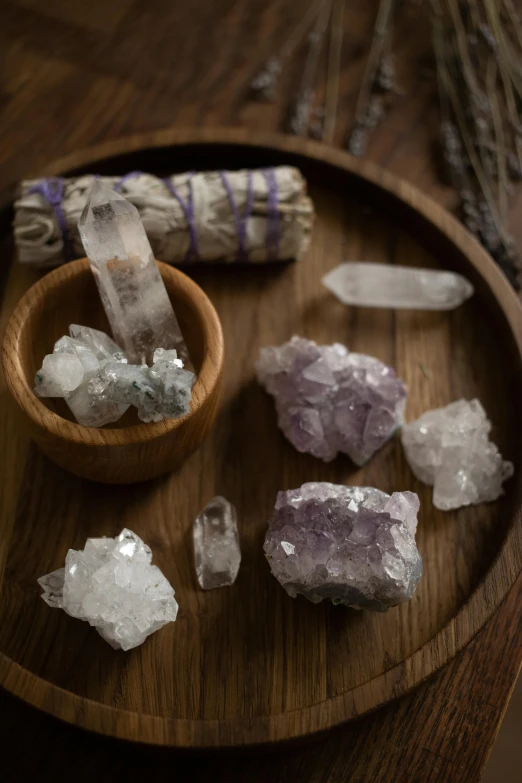 a wooden plate topped with crystals on top of a wooden table, by Linda Sutton, trending on unsplash, purple crystals, dust and rock theme, various sizes, white