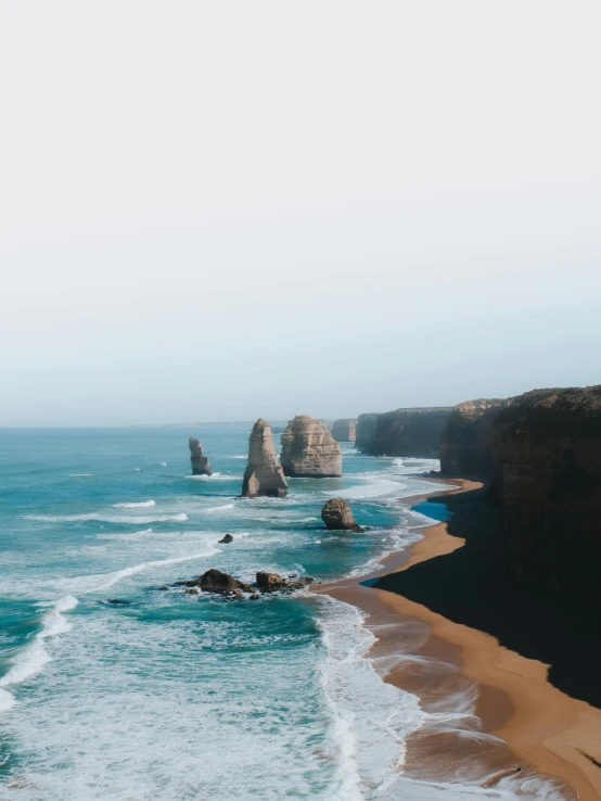 a large body of water next to a sandy beach, pexels contest winner, coastal cliffs, melbourne, profile image, stacked image