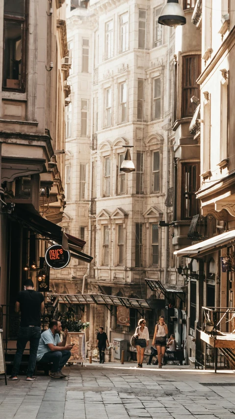 a group of people walking down a street next to tall buildings, by irakli nadar, pexels contest winner, art nouveau, ottoman empire, a quaint, afternoon sunlight, ivory and copper