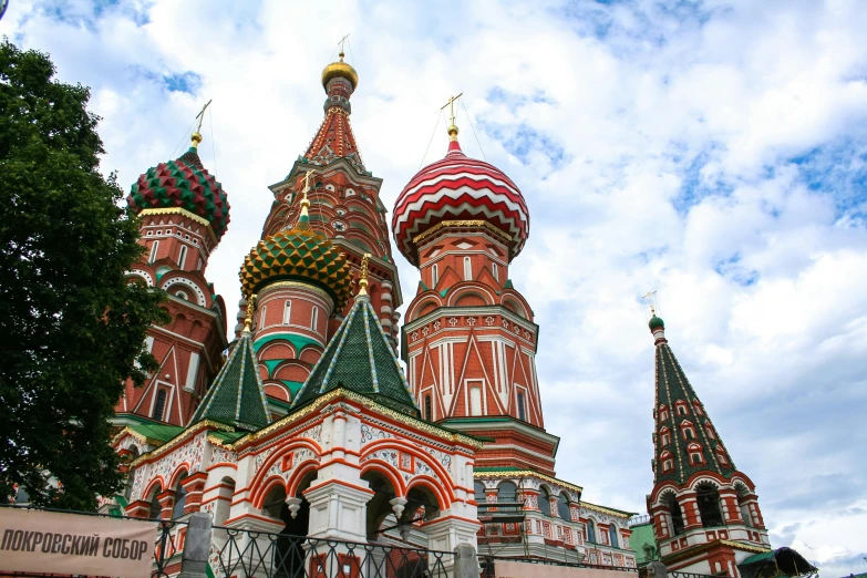 a group of people standing in front of a building, an album cover, inspired by Vasily Surikov, pexels contest winner, black domes and spires, vibrant red and green colours, square, 000 — википедия