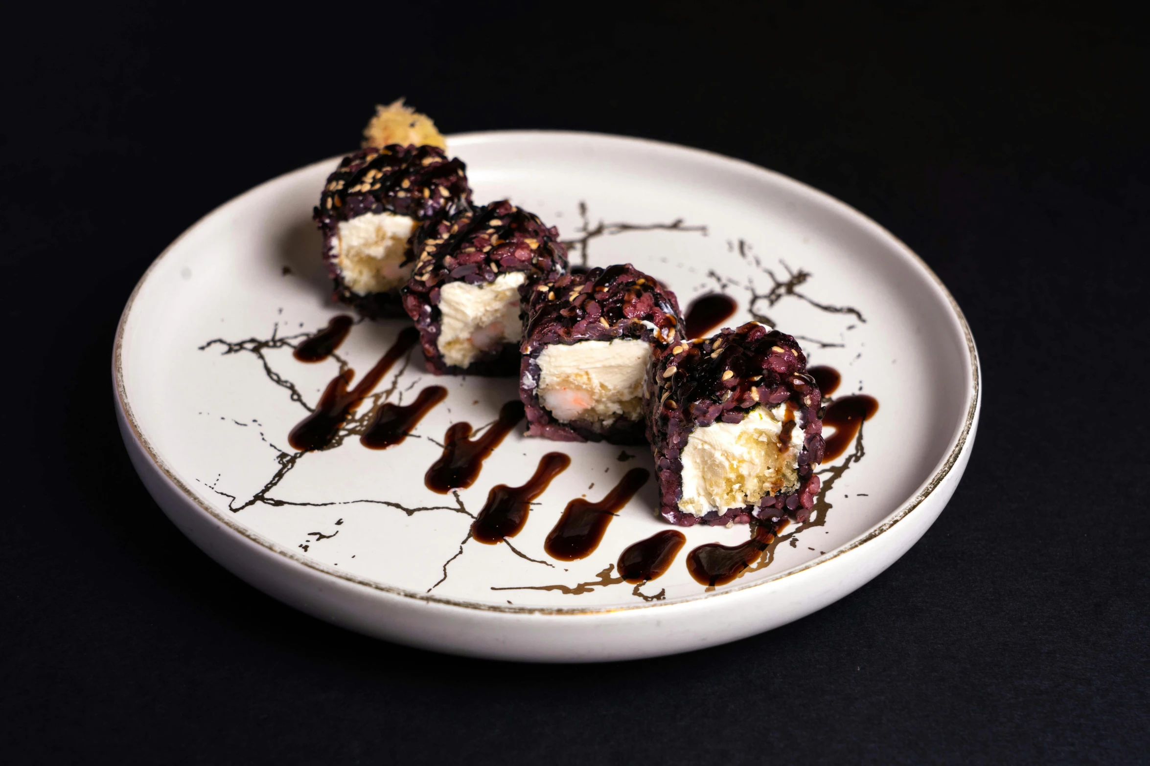 a close up of a plate of food on a table, inspired by Maki Haku, black white purple, marshmallow, chocolate, charred