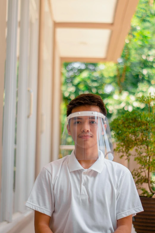 a man sitting on a porch next to a potted plant, visor screen for face, made of plastic, teen boy, david luong