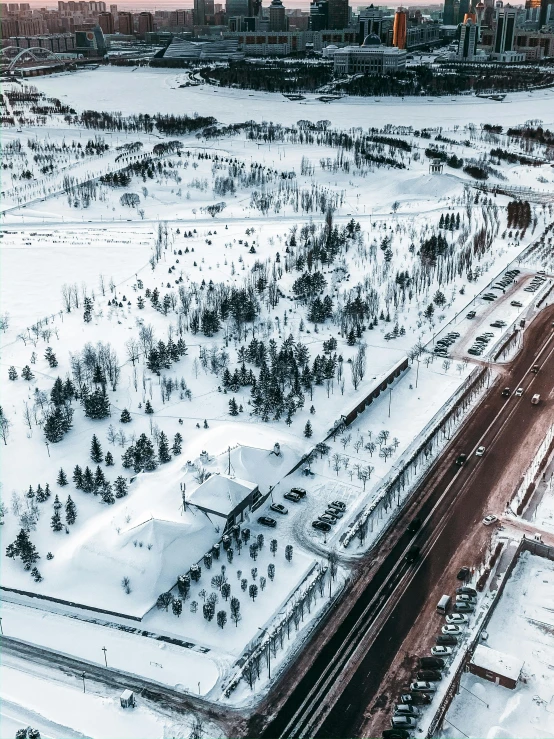 an aerial view of a city covered in snow, by Roar Kjernstad, pexels contest winner, graffiti, thumbnail, square, train station, low quality photo