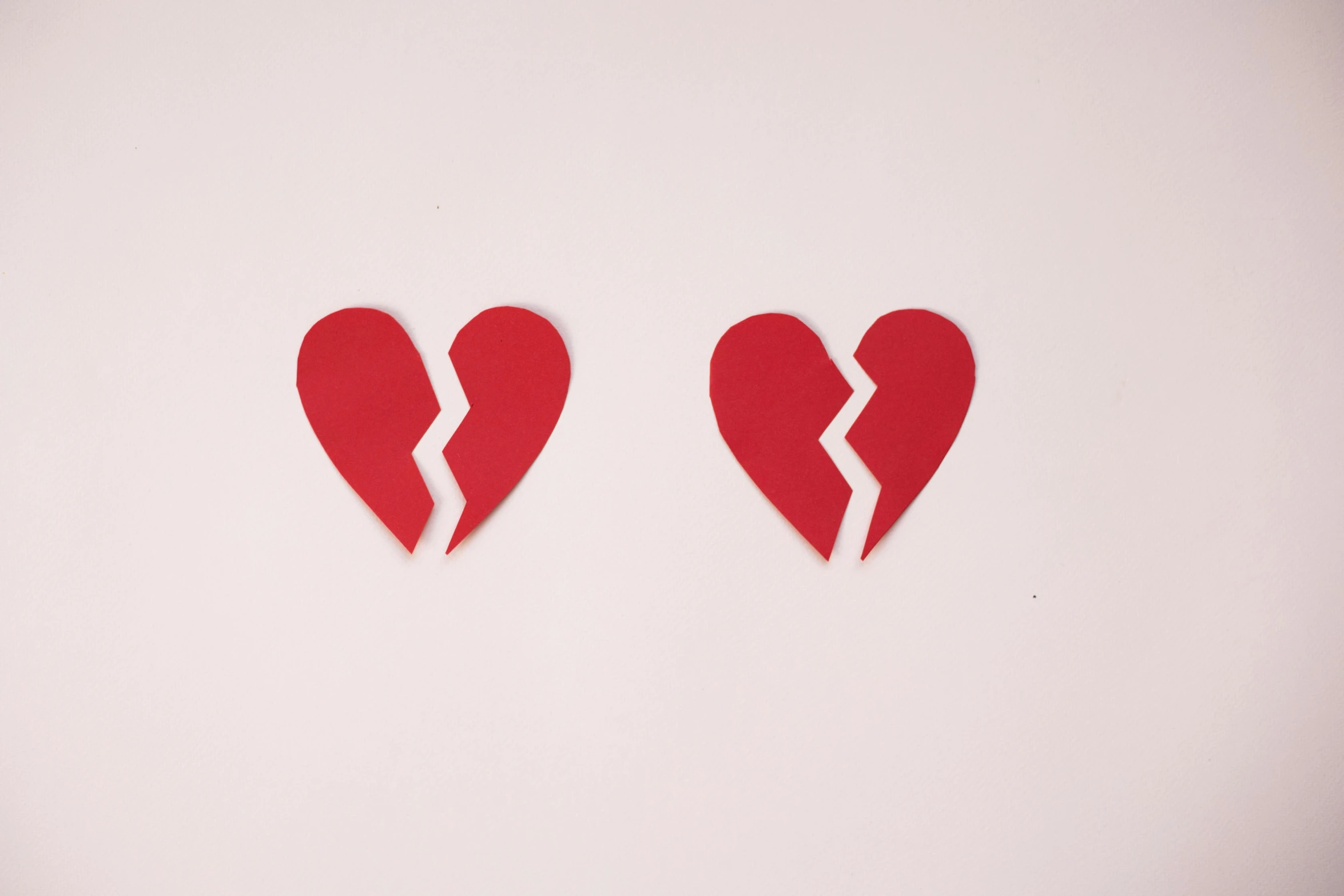 two pieces of paper cut into the shape of a broken heart, trending on pexels, identical, plain background, broken toys, ariel perez