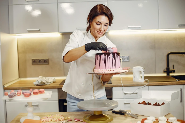 a woman decorating a cake in a kitchen, pexels contest winner, arbeitsrat für kunst, brown and pink color scheme, 9 9 designs, profile image, sofya emelenko