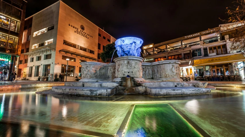 a fountain in the middle of a city at night, a marble sculpture, wellington, pristine and clean, byzantine, high-quality photo