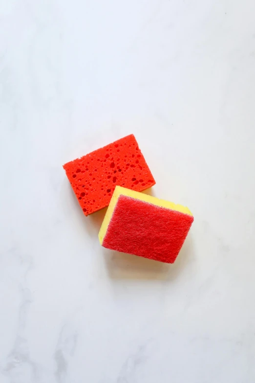 a couple of sponges sitting on top of a counter, bright red, 2 colors, mini, reverse