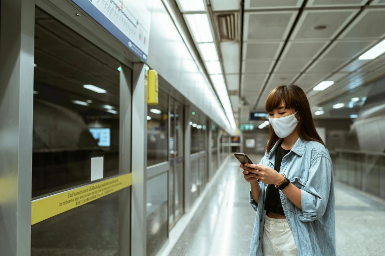 a woman with a face mask looking at her phone, a picture, underground, avatar image, square, thailand