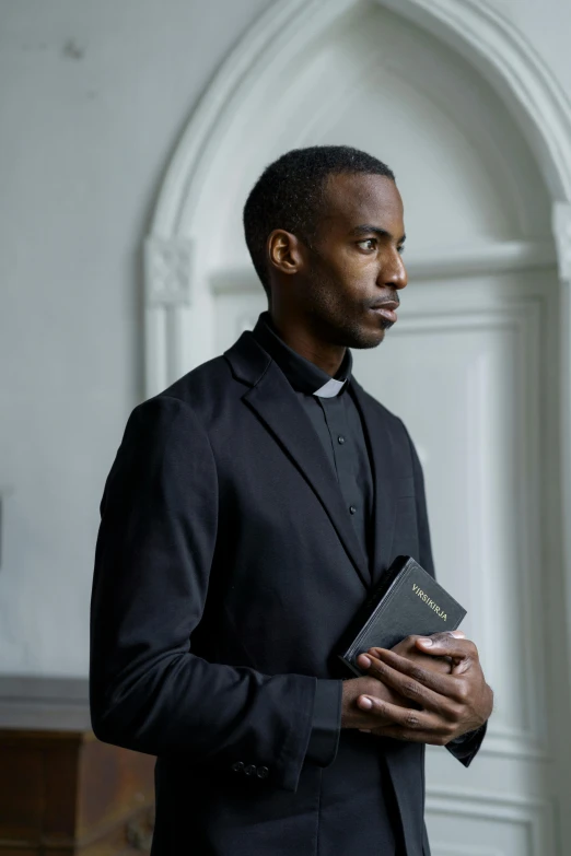 a man in a suit holding a bible, inspired by Edward Okuń, scene set in a church, wearing a black shirt, gilleard james, wearing collar