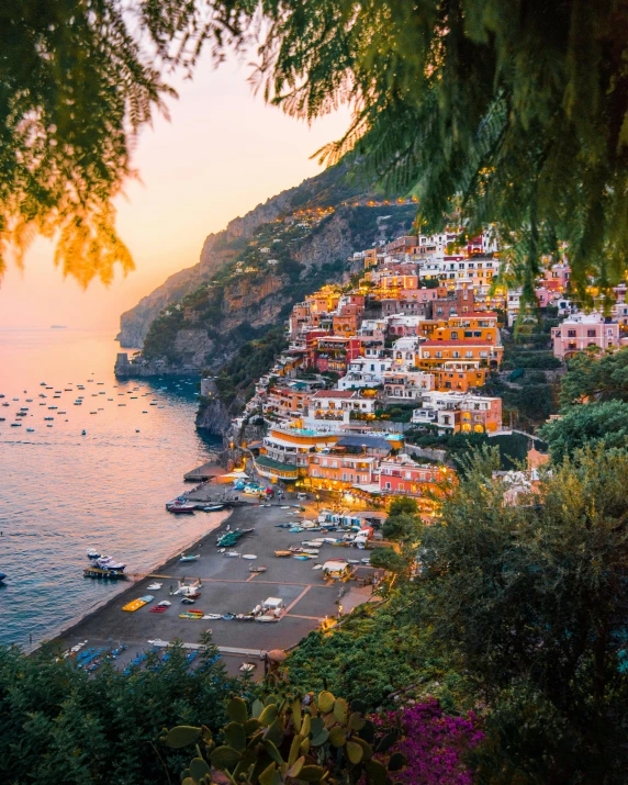 a large body of water next to a lush green hillside, pexels contest winner, renaissance, small port village, cliff side at dusk, pink arches, conde nast traveler photo