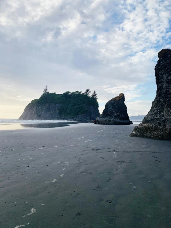 a couple of rocks sitting on top of a sandy beach, big arches in the back, profile image, multiple stories, washington