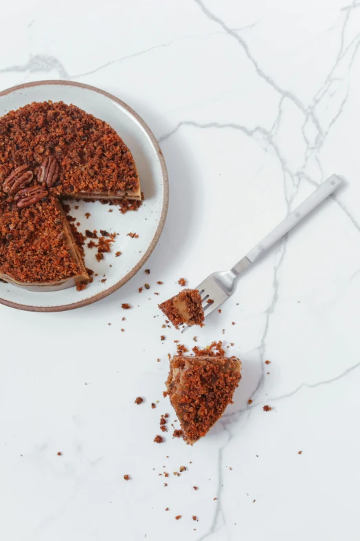 a piece of cake sitting on top of a plate, inspired by Reuben Tam, trending on pexels, textured base ; product photos, ground broken, brown, birdseye view