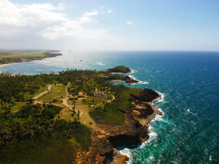 a large body of water next to a lush green hillside, an album cover, pexels contest winner, hurufiyya, cuba, ocean cliff view, aerial view of an ancient land, thumbnail