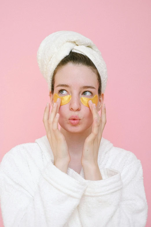 a woman with orange slices on her face, by Julia Pishtar, trending on pexels, renaissance, black eye mask, yellow backdrop, putting makeup on, bubbly