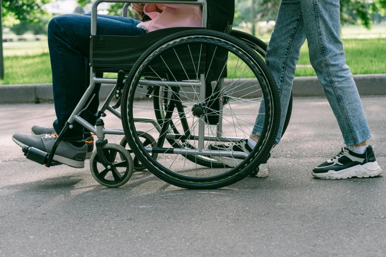 a woman pushing a man in a wheel chair, pixabay, hurufiyya, background image, paul barson, mid shot photo, thumbnail