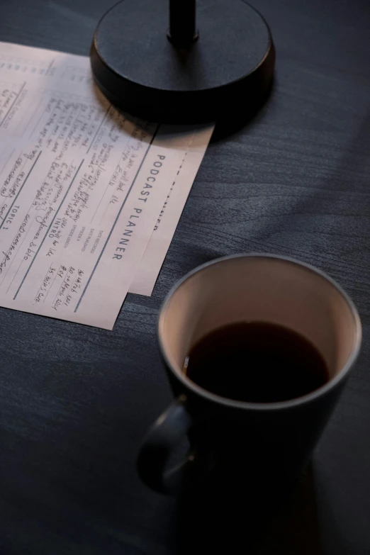 a cup of coffee sitting on top of a table, by Jesper Knudsen, service ticket close up, matte black paper, with notes, uncropped