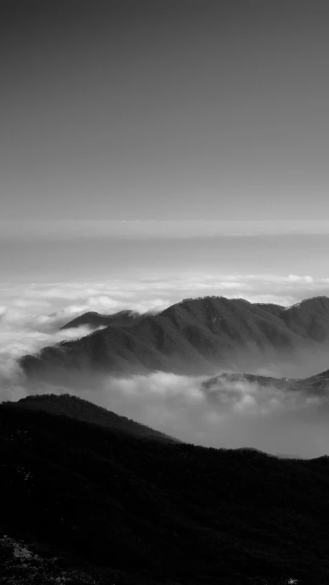 a black and white photo of a mountain range, kumamoto, :: morning, taiwan, above the clouds