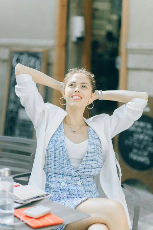 a woman sitting at a table with her arms behind her head, trending on pexels, happy fashion model, gif, in style of lam manh, 15081959 21121991 01012000 4k