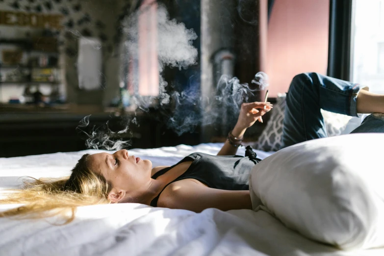 a woman laying on a bed smoking a cigarette, trending on pexels, happening, holding a small vape, leaving a room, instagram photo, smoking a bowl of hash together