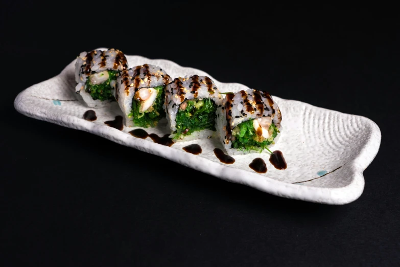 a close up of a plate of food on a table, sushi, green and white, detailed product image, profile shot