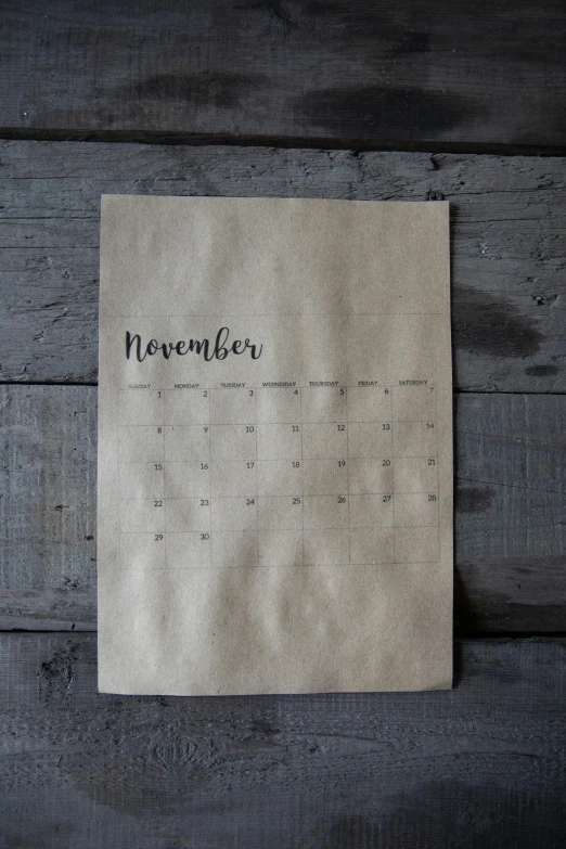 a piece of paper with the word november written on it, trending on unsplash, light - brown wall, it's morbin time, screen printed, 1 6 x 1 6