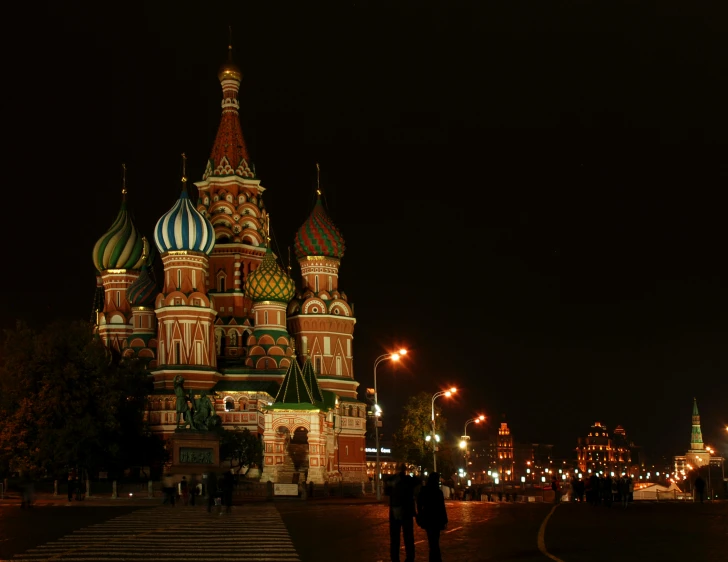 a couple of people that are standing in the street, an album cover, by Andrei Kolkoutine, pexels contest winner, russian temple, nighttime!!, square, cathedrals