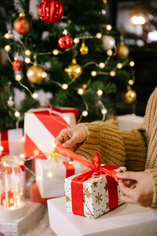 a woman opening presents in front of a christmas tree, by Julia Pishtar, happening, square, dynamic closeup, abcdefghijklmnopqrstuvwxyz, brand