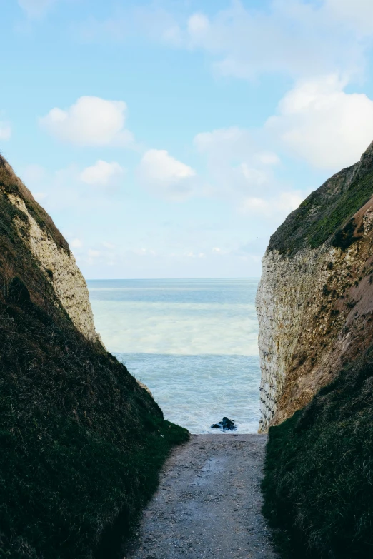 a narrow path leading to the ocean on a sunny day, unsplash, les nabis, chalk cliffs above, ww1 trench, 4k”