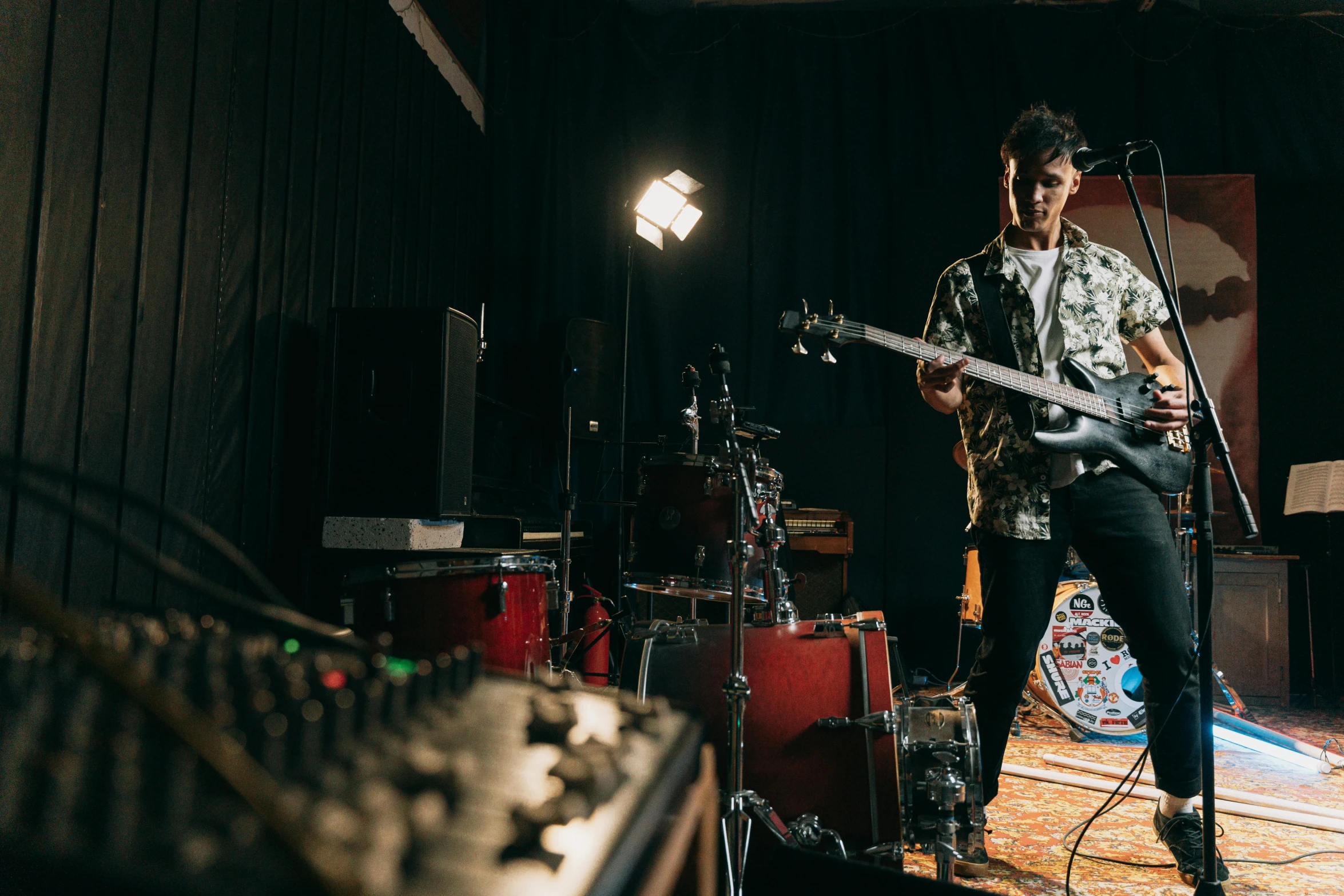 a man that is playing a guitar in a room, unsplash, multiple bass drums, lachlan bailey, iren horrors, studio photo