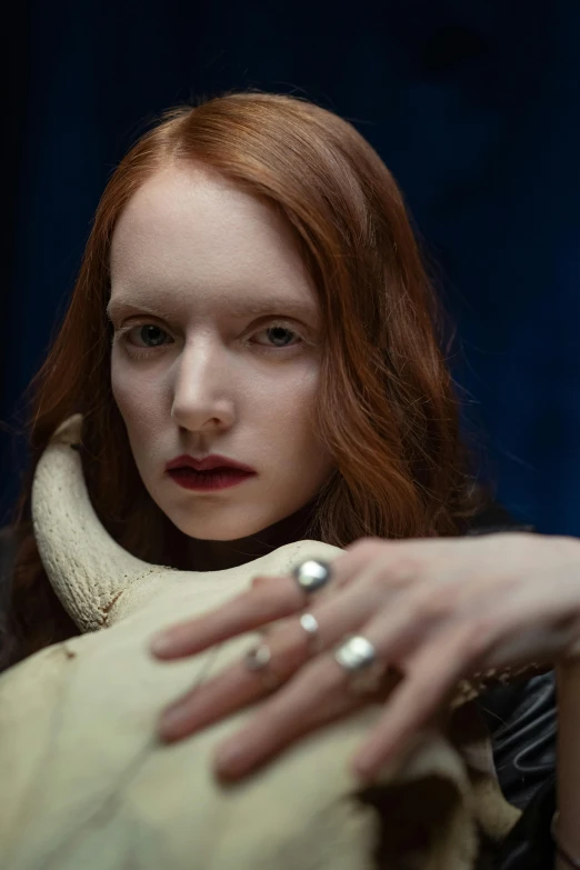 a close up of a person holding a stuffed animal, an album cover, inspired by Lucas Cranach the Elder, trending on pexels, renaissance, portrait of beautiful vampire, bone jewellery, hr ginger, using leather armour with bones