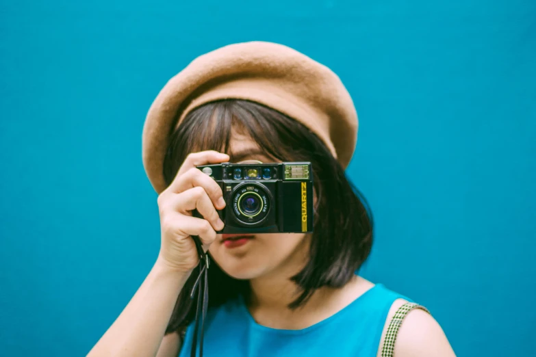 a woman taking a picture with a camera, a picture, inspired by Elsa Bleda, unsplash contest winner, with a blue background, an asian woman, retro colour, on a yellow canva