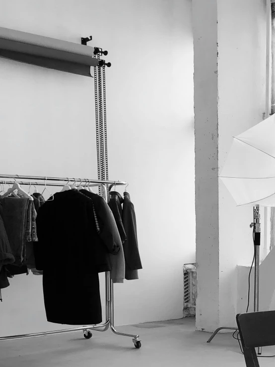 a black and white photo of a woman holding an umbrella, a photo, by Zofia Stryjenska, postminimalism, fashion week backstage, picture of a loft in morning, 'white background'!!!, editorial footage