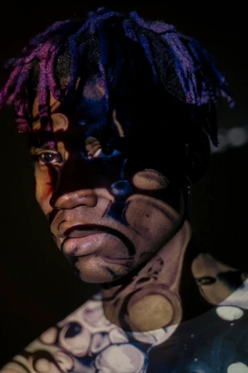 a close up of a person with a painted face, an album cover, trending on pexels, afrofuturism, xxxtentacion, dark purple skin, full view with focus on subject, ( ( theatrical ) )
