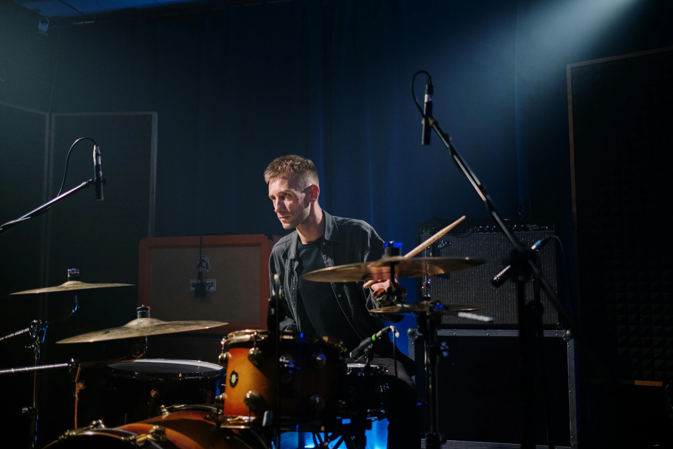 a man that is sitting in front of a drum, sitting in front of a microphone, drumkit, shot on sony a 7, cinematic-shot