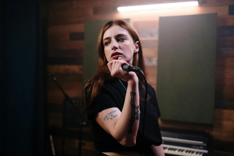 a woman singing into a microphone in a recording studio, a portrait, inspired by Elsa Bleda, trending on pexels, antipodeans, looks like a mix of grimes, hand on her chin, walking down, promotional image