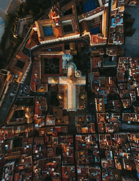 an aerial view of a city with lots of buildings, by Sam Black, pexels contest winner, romanesque, holy cross, volumetric lighting from above, spanish, color photo