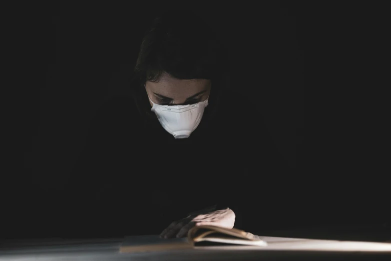 a person wearing a face mask reading a book, inspired by Nicola Samori, crawling out of a dark room, scientific research, dusty air, profile image