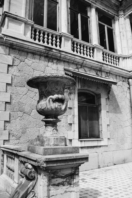 a black and white photo of a building, a statue, inspired by André Kertész, overturned ornate chalice, in balcony of palace, ( ( photograph ) ), unknown location