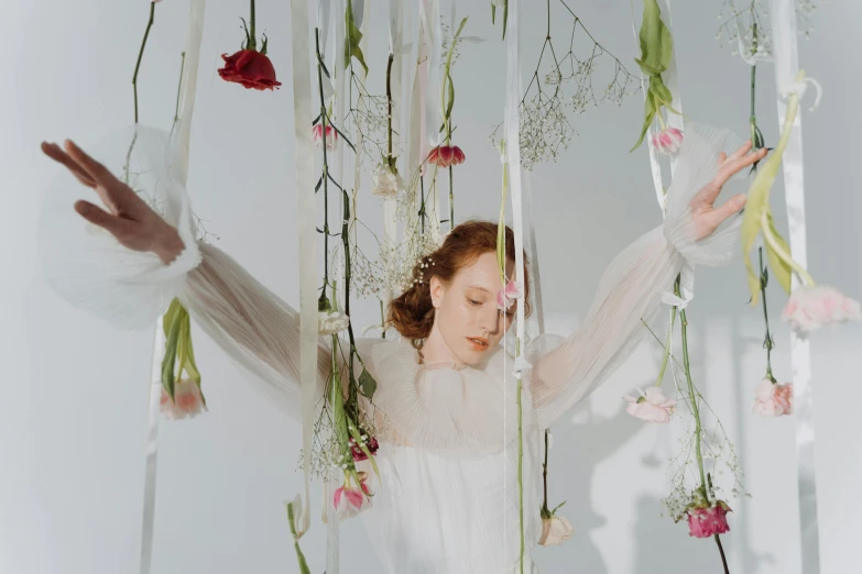 a woman standing in front of a bunch of flowers, inspired by Cecil Beaton, pexels contest winner, neo-romanticism, hanging from white web, sadie sink, floating bodies, laces and ribbons