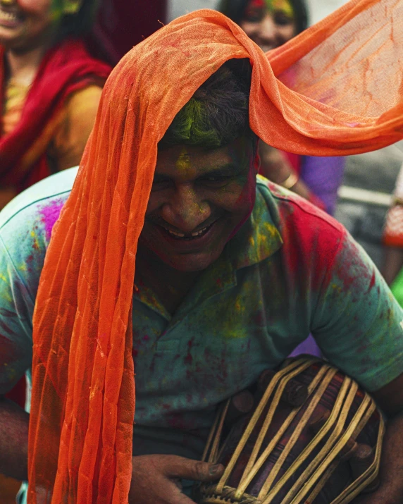 a close up of a person playing a musical instrument, an album cover, trending on unsplash, bengal school of art, pride parade, rainbow colored dust mask, he is dancing, looking towards camera