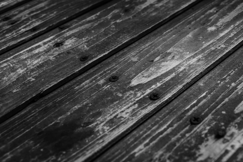 a black and white photo of a wooden floor, by Kristian Zahrtmann, unsplash, covered with tar, rivets, deck, colorless