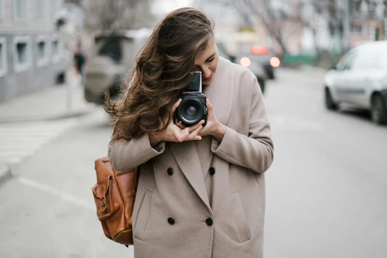 a woman taking a picture with a camera, pexels contest winner, girl with brown hair, walking towards camera, professional profile picture, lovingly looking at camera