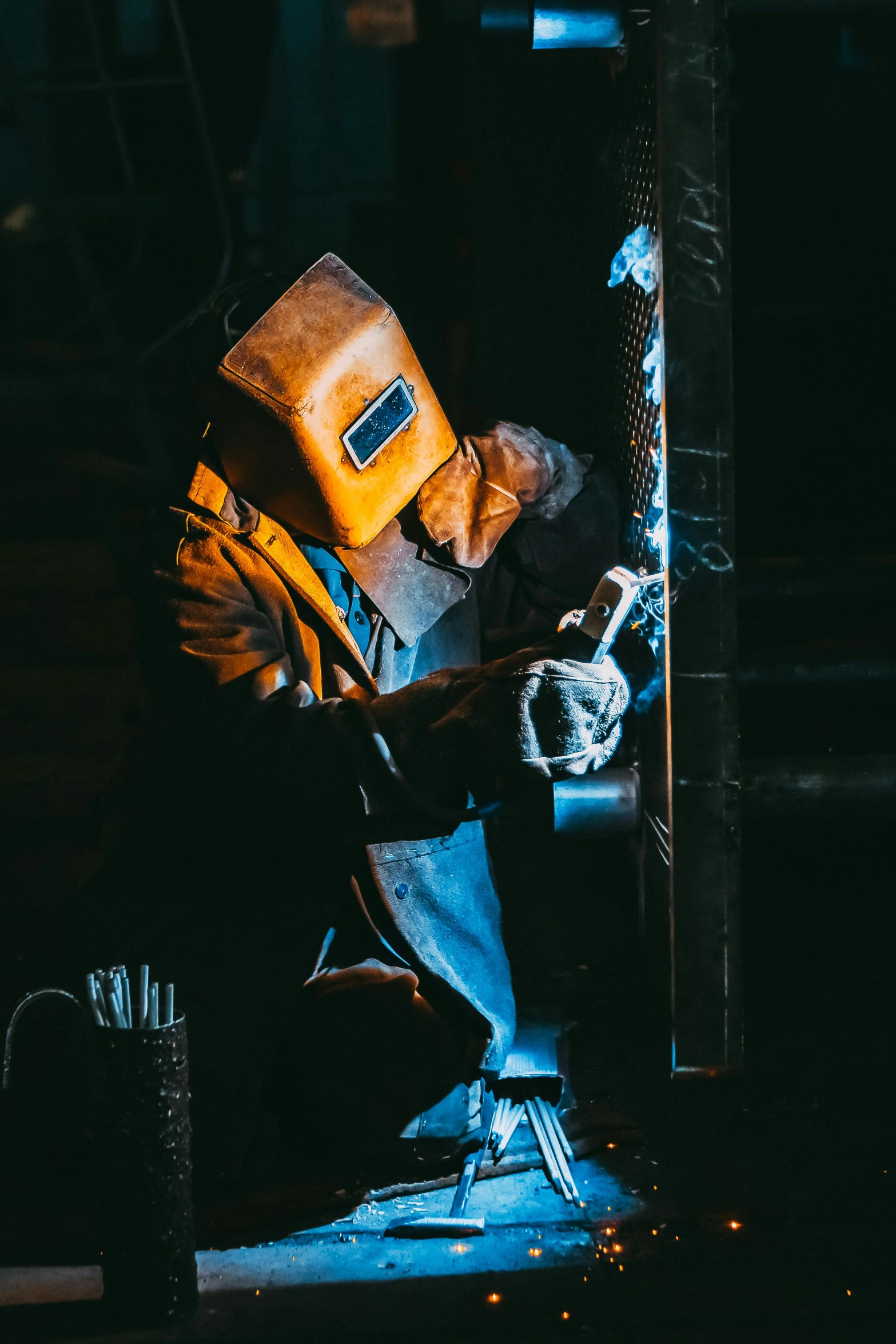 a welder working on a pole in the dark, pexels contest winner, renaissance, reflective material, profile image, sitting down, kevlar