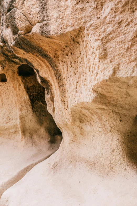 a large rock formation in the middle of a desert, a cave painting, by Lee Loughridge, unsplash contest winner, sand - colored walls, cyprus, detail shots, curves