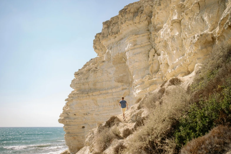 a man standing on top of a cliff next to the ocean, les nabis, over a chalk cliff, profile image, cyprus, ochre